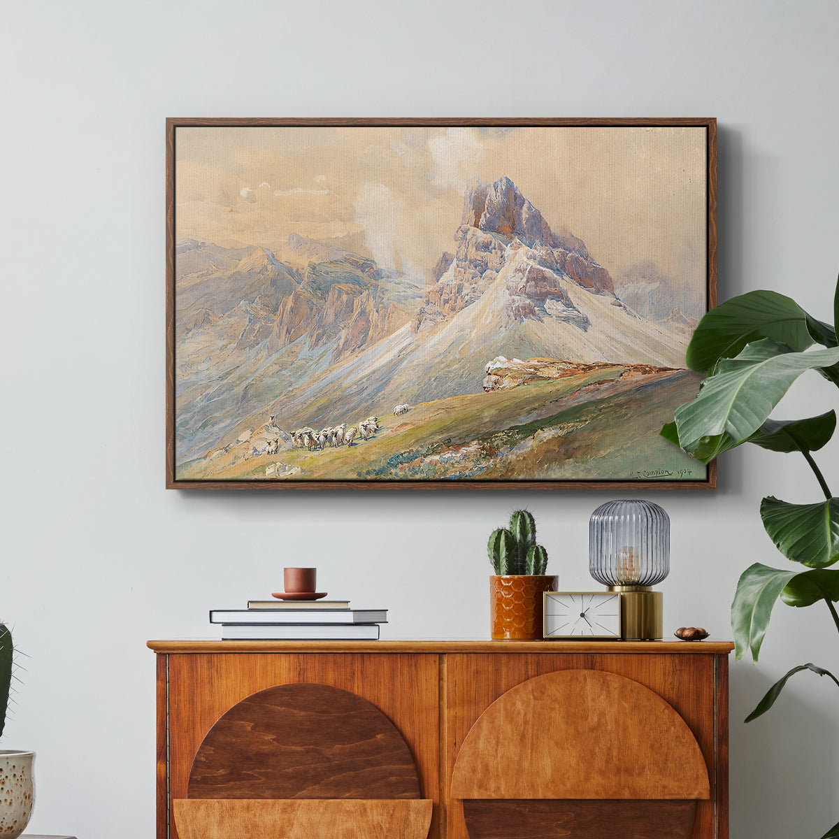 From the Dolomites, 1904 by Edward Theodore Compton in a walnut floater framed canvas featuring dramatic Dolomite mountain peaks rising above rugged terrain, displayed above a wood console cabinet.