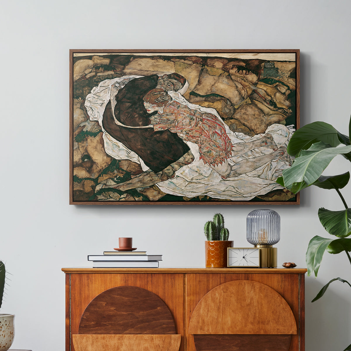 Death and the Maiden, 1915 by Egon Schiele in a walnut floater framed canvas featuring intertwined figures representing death and woman in emotional embrace, displayed above a wood console cabinet.
