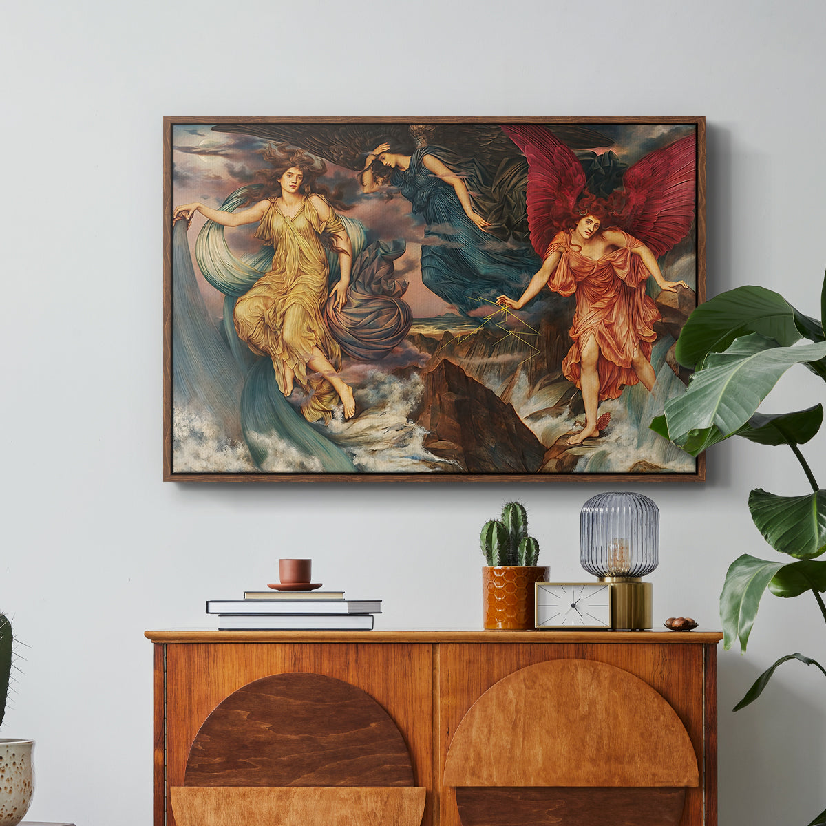The Storm Spirits, 1900 by Evelyn De Morgan in a walnut floater framed canvas featuring multiple figures swirling through sky representing storm forces in motion, displayed above a wood console cabinet.