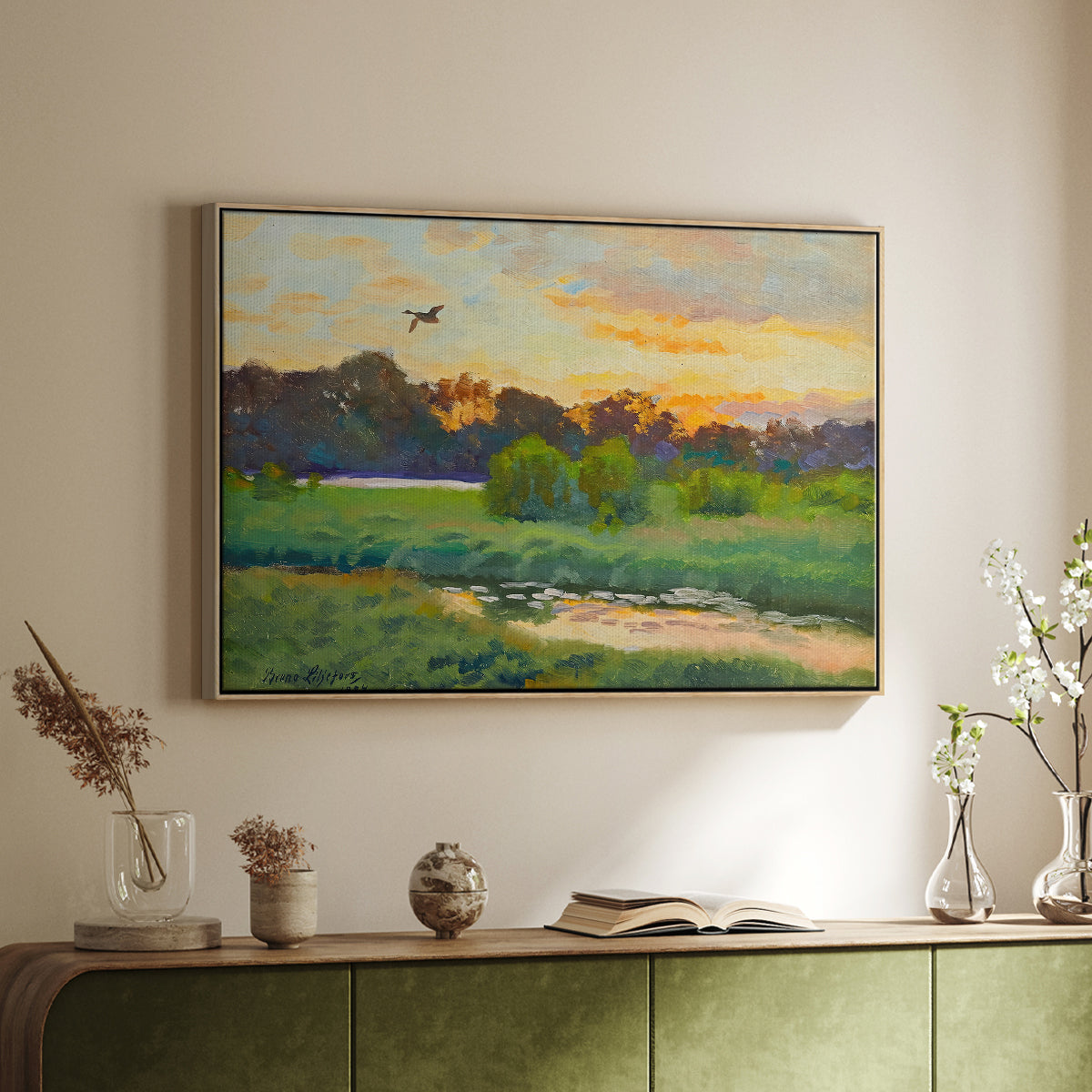 Natural wood floater framed canvas of Flying Duck at Sunset, 1924 by Bruno Liljefors, featuring a lone duck soaring over a glowing marshland above a sideboard in a softly lit hallway.