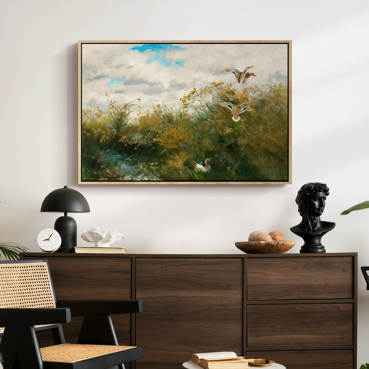 Wild Ducks (Grasänder), 1890 by Bruno Liljefors displayed in a natural wood floater framed canvas above a dark wood credenza in an entryway.