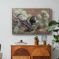 Hooded Crows (Kråkor), 1891 by Bruno Liljefors in a natural wood floater framed canvas featuring two crows perched on ground among grass and earth tones, displayed above a wood console cabinet.