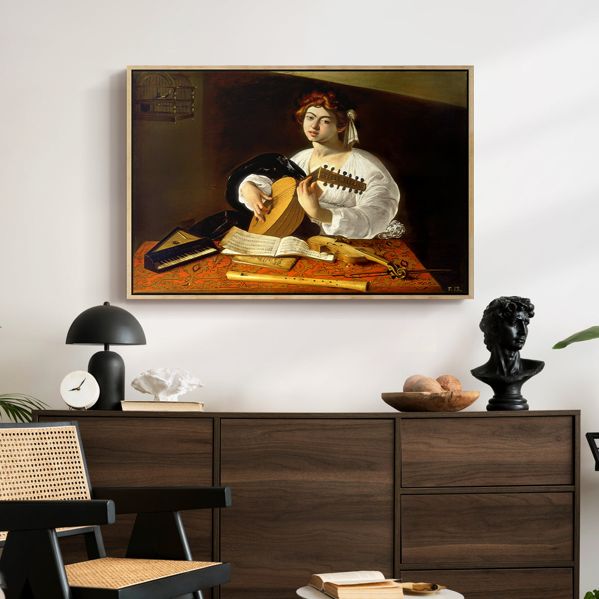 The Lute Player (Wildenstein Version), c. 1596 by Caravaggio displayed in a natural wood floater framed canvas above a dark wood credenza in an entryway.