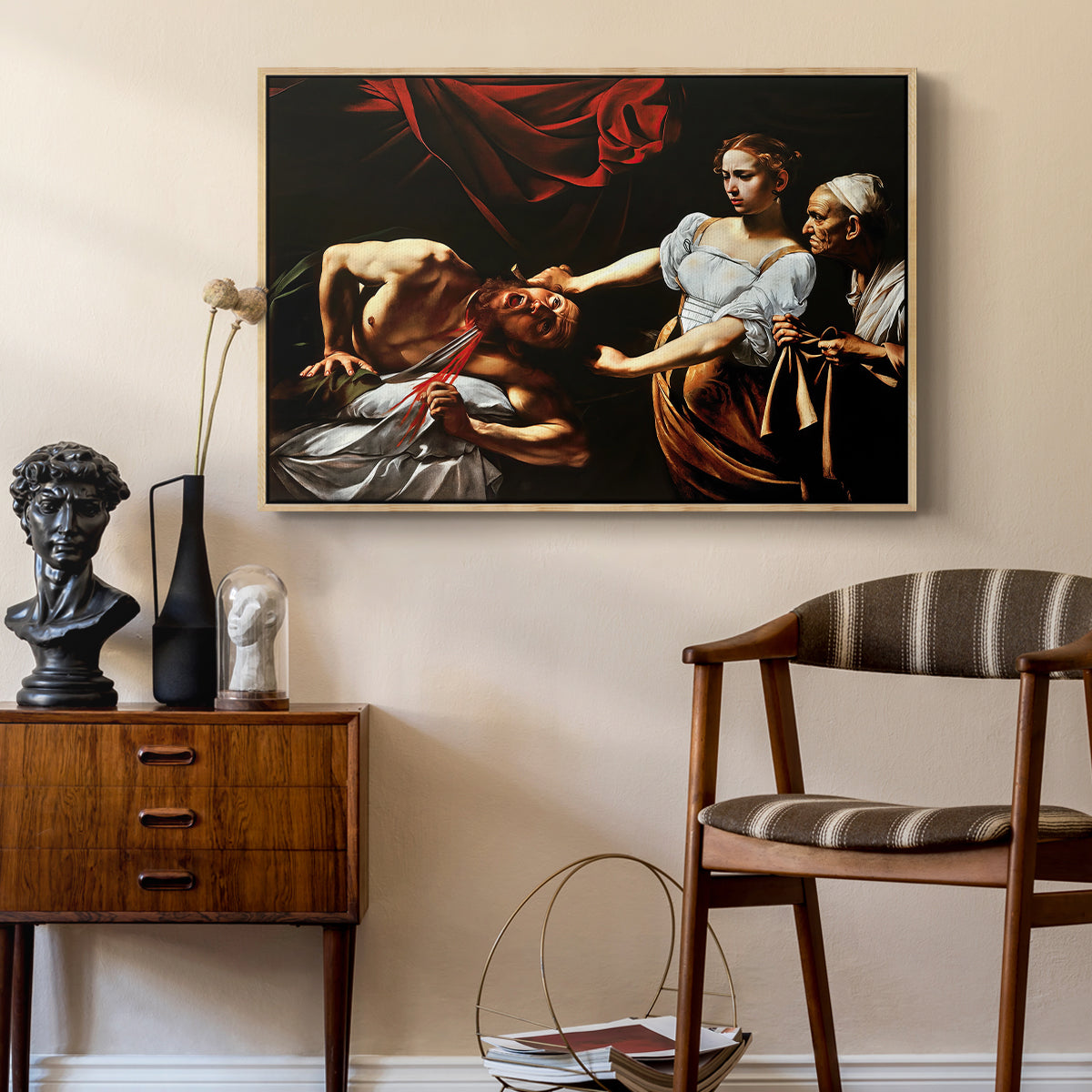 Judith Beheading Holofernes, c. 1599 by Caravaggio as a natural wood floater framed canvas featuring an intense moment of Judith slaying Holofernes with sword, styled above a mid-century console in a contemporary living area.