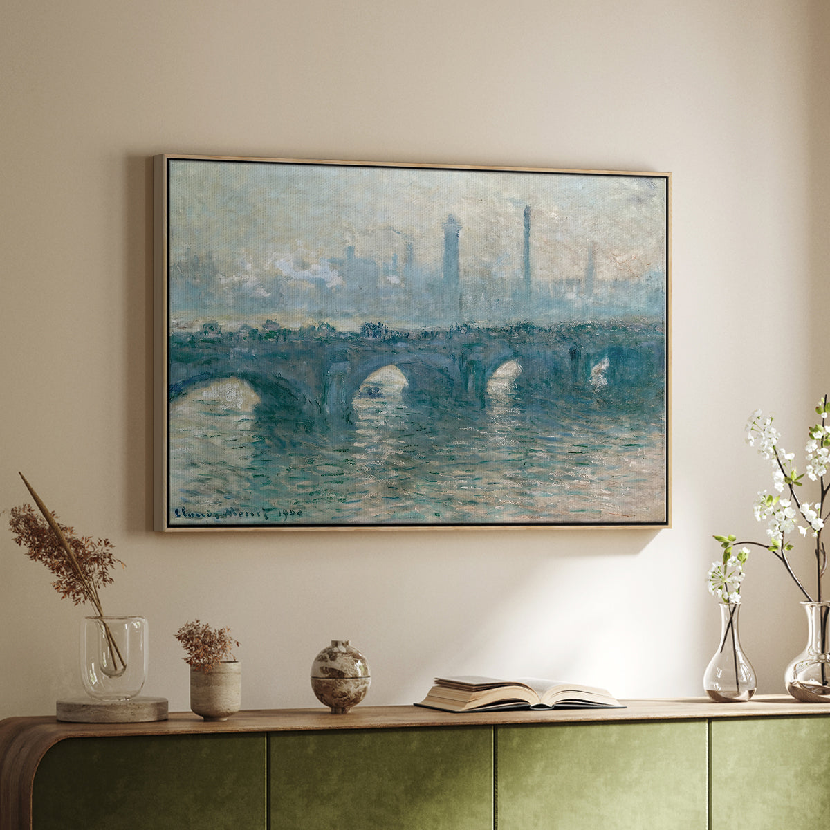 Natural wood floater framed canvas of Waterloo Bridge, Gray Weather, 1900 by Claude Monet, featuring an impressionist cityscape with bridge fading into fog over water above a sideboard in a softly lit hallway.