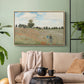 Natural wood floater framed canvas featuring a rural landscape with scattered figures among blooming flowers, displayed above a sofa in a modern living room.