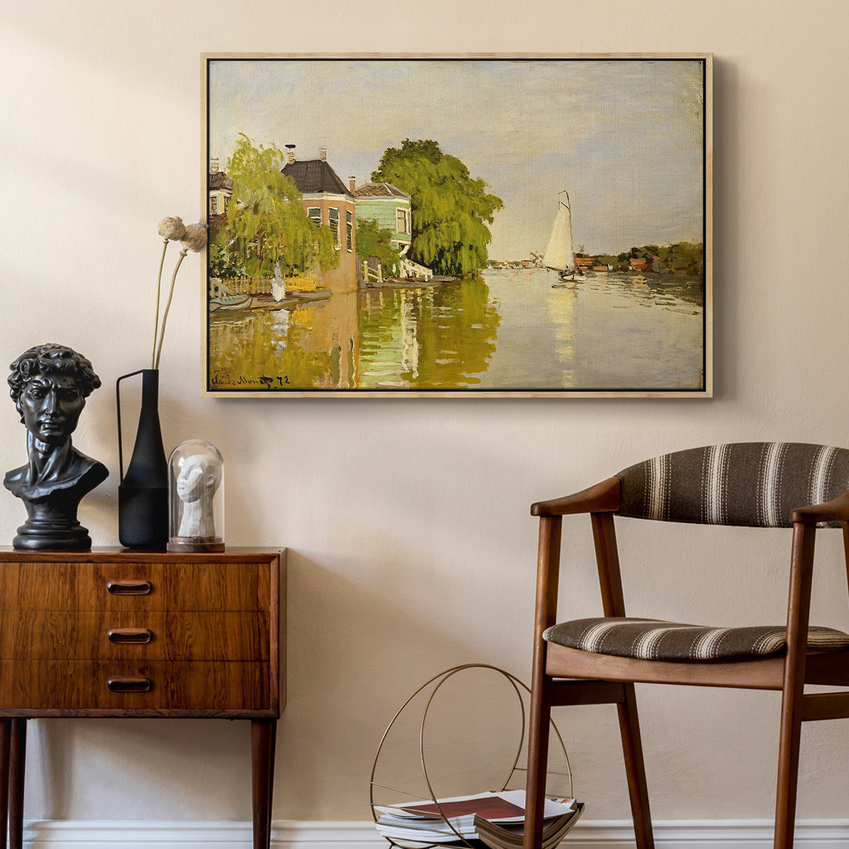 Houses on the Achterzaan, 1871 by Claude Monet as a natural wood floater framed canvas featuring an impressionist landscape with buildings along quiet canal, styled above a mid-century console in a contemporary living area.