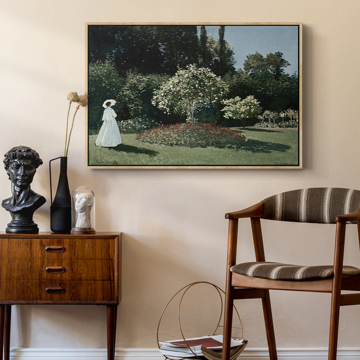Woman in the Garden, Sainte-Adresse, 1867 by Claude Monet as a natural wood floater framed canvas featuring an elegant woman posed outdoors among blooming plants, styled above a mid-century console in a contemporary living area.