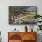 On the Bank of the Seine, Bennecourt, 1868 by Claude Monet in a natural wood floater framed canvas featuring a woman and child seated along riverbank beneath trees in soft daylight, displayed above a wood console cabinet.