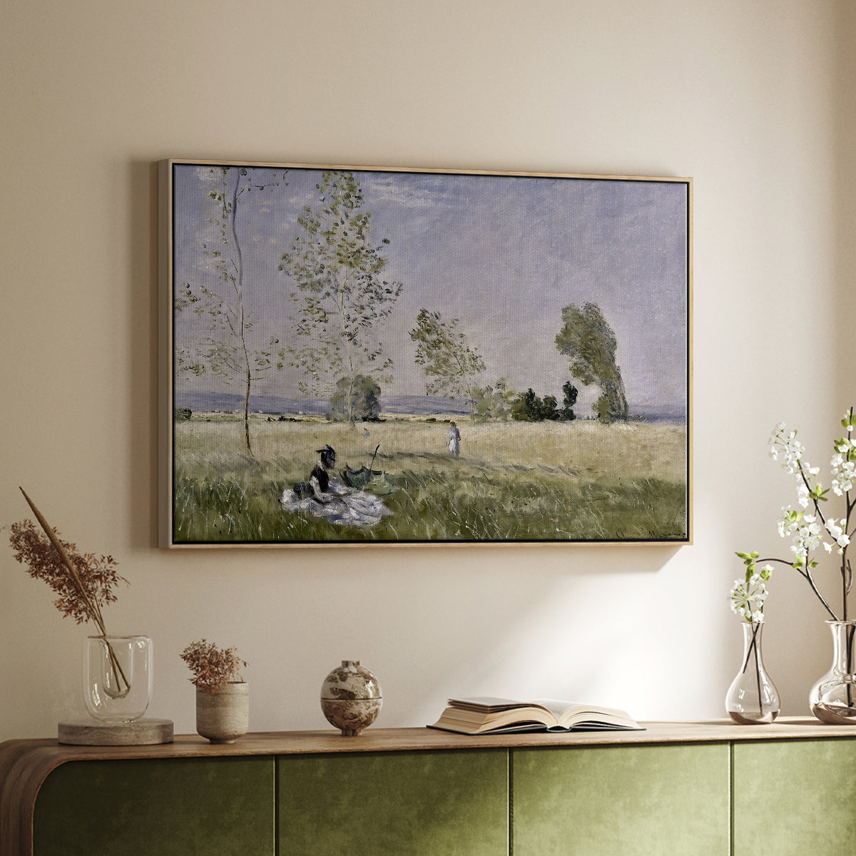 Natural wood floater framed canvas of Summer (L'ete), 1874 by Claude Monet, featuring an impressionist countryside scene with figure resting in shade above a sideboard in a softly lit hallway.