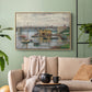 Natural wood floater framed canvas featuring a subdued urban landscape with structure spanning river, displayed above a sofa in a modern living room.