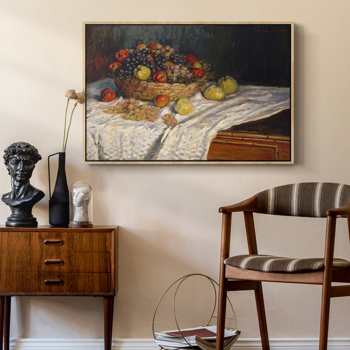 Still Life with Apples and Grapes, 1880 by Claude Monet as a natural wood floater framed canvas featuring a close-up of apples and grapes in warm tones, styled above a mid-century console in a contemporary living area.