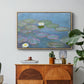Water Lilies (Nymphéas), 1897-1899 by Claude Monet in a natural wood floater framed canvas featuring floating water lilies on pond with reflections of sky and foliage, displayed above a wood console cabinet.