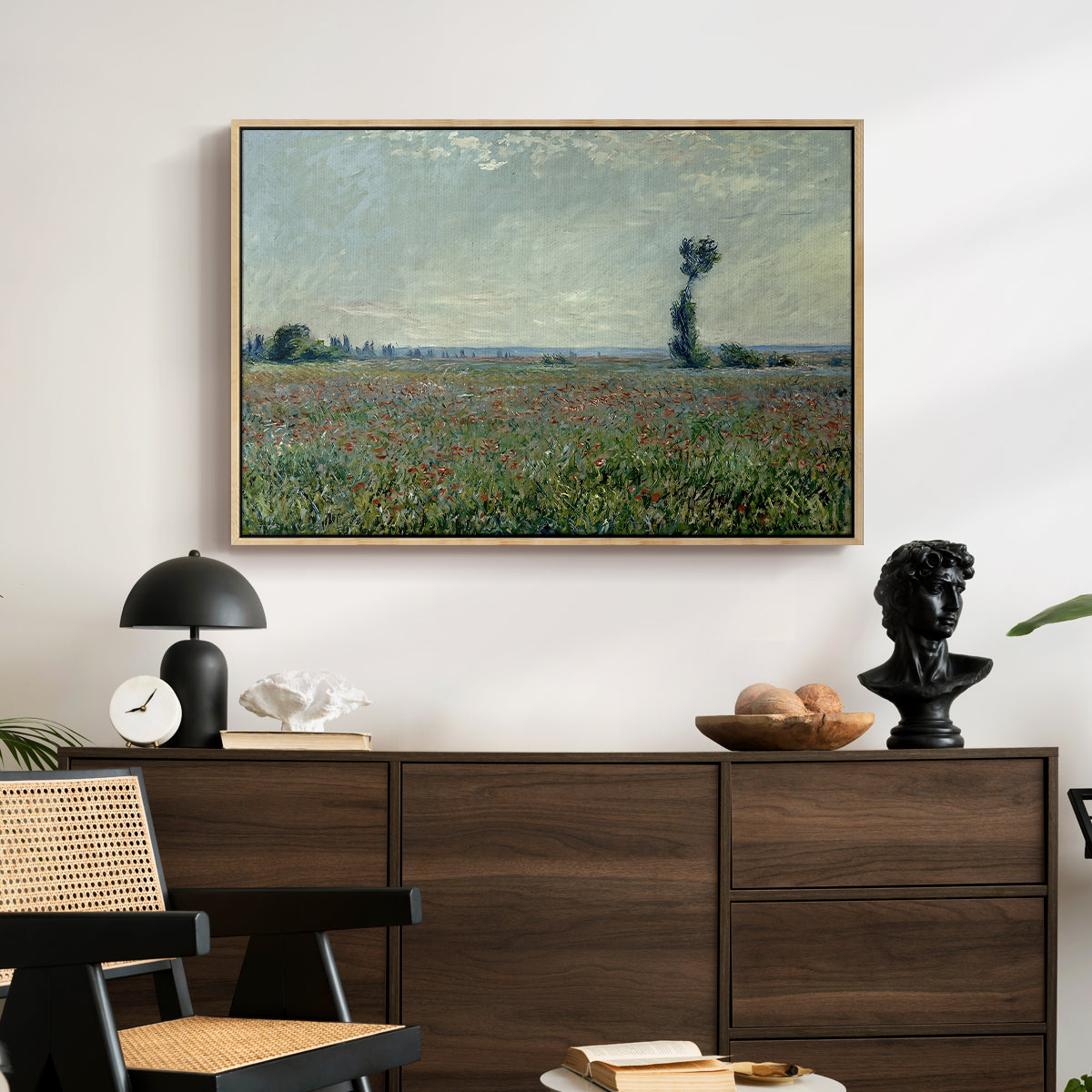 Poppy Field, 1881 by Claude Monet displayed in a natural wood floater framed canvas above a dark wood credenza in an entryway.