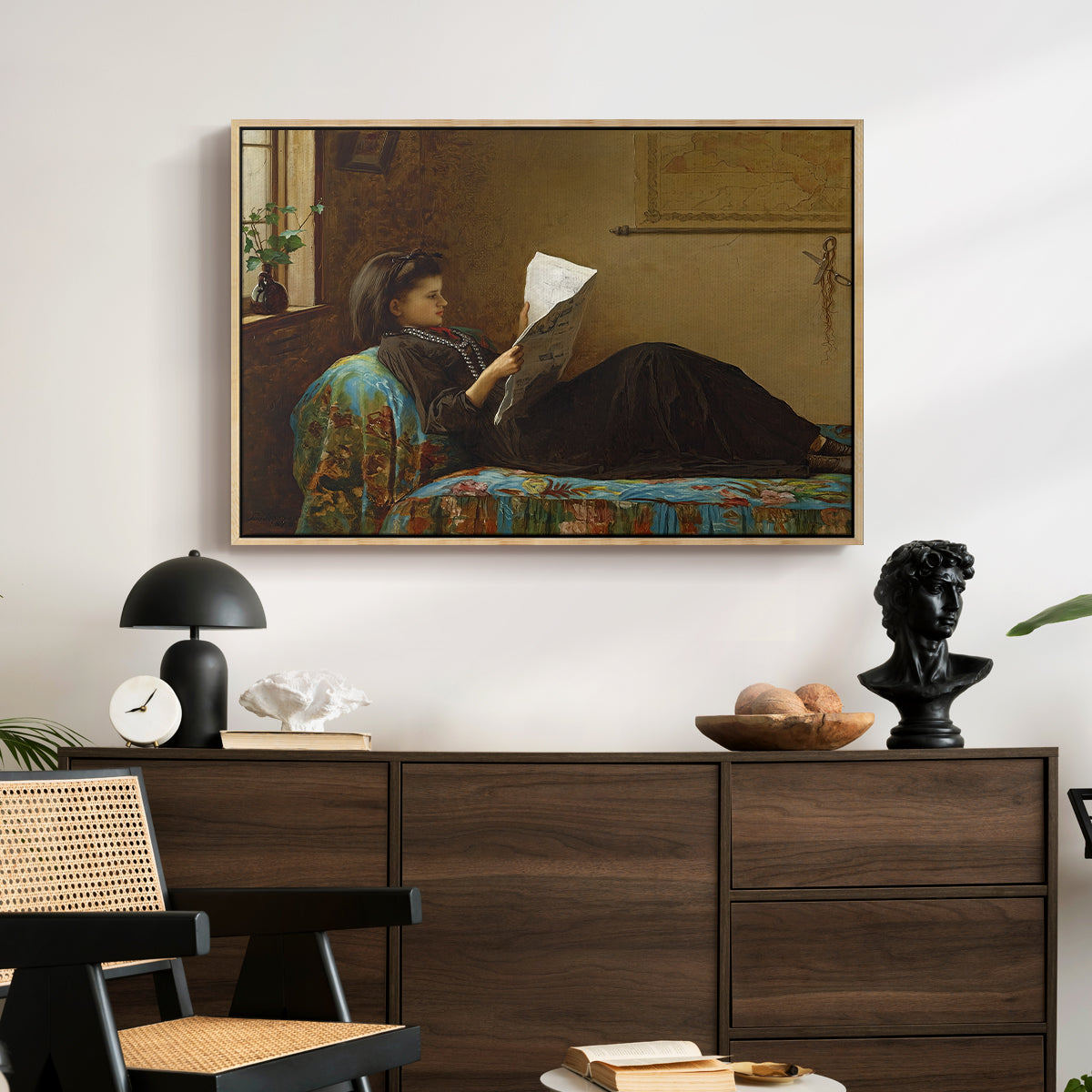 Interesting News, 1872 by Eastman Johnson displayed in a natural wood floater framed canvas above a dark wood credenza in an entryway.