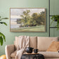 Natural wood floater framed canvas featuring a tranquil lakeside view with soft atmospheric tones, displayed above a sofa in a modern living room.