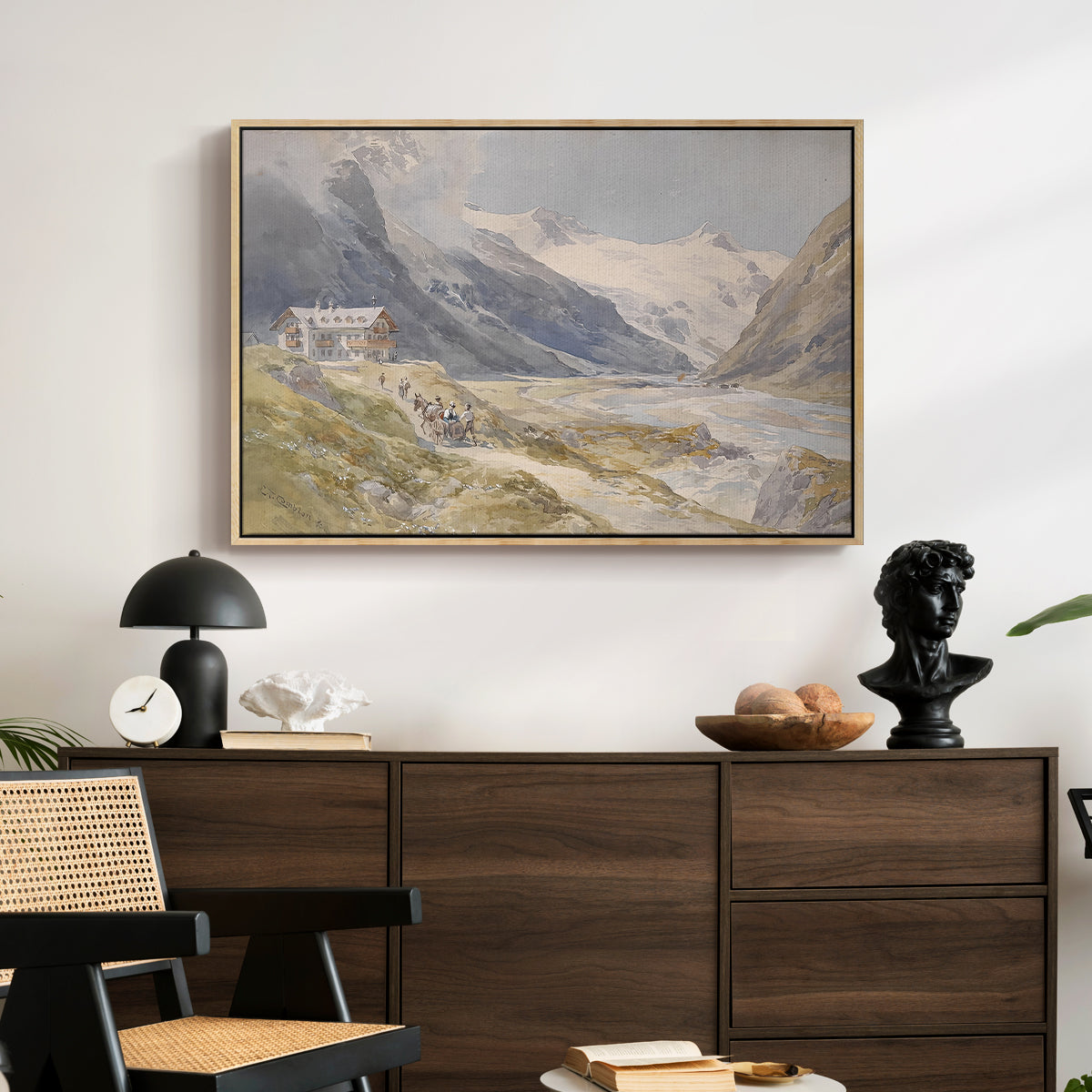 Shepherds (Pasterze), c. 1921 by Edward Theodore Compton displayed in a natural wood floater framed canvas above a dark wood credenza in an entryway.