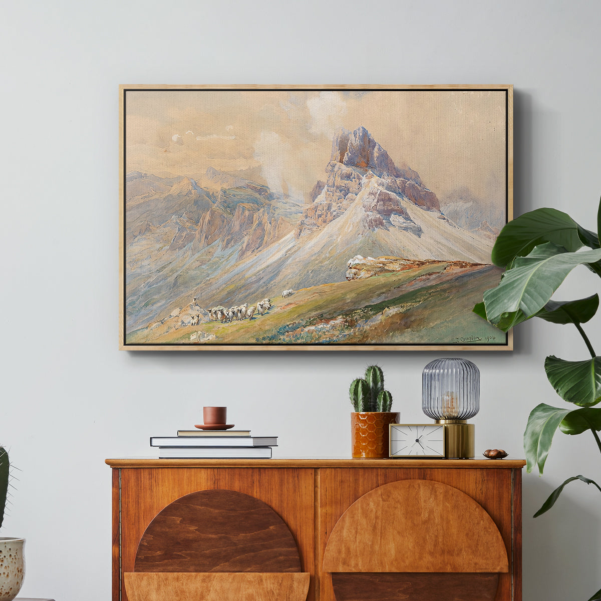 From the Dolomites, 1904 by Edward Theodore Compton in a natural wood floater framed canvas featuring dramatic Dolomite mountain peaks rising above rugged terrain, displayed above a wood console cabinet.