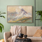 Natural wood floater framed canvas featuring a realistic mountain view with strong geological forms, displayed above a sofa in a modern living room.