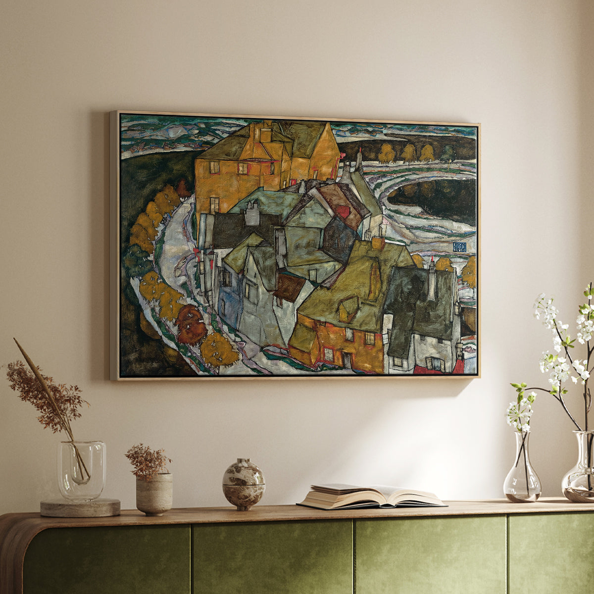Natural wood floater framed canvas of Crescent of Houses II (Island Town), 1915 by Egon Schiele, featuring a stylized townscape with clustered buildings and bold outlines above a sideboard in a softly lit hallway.