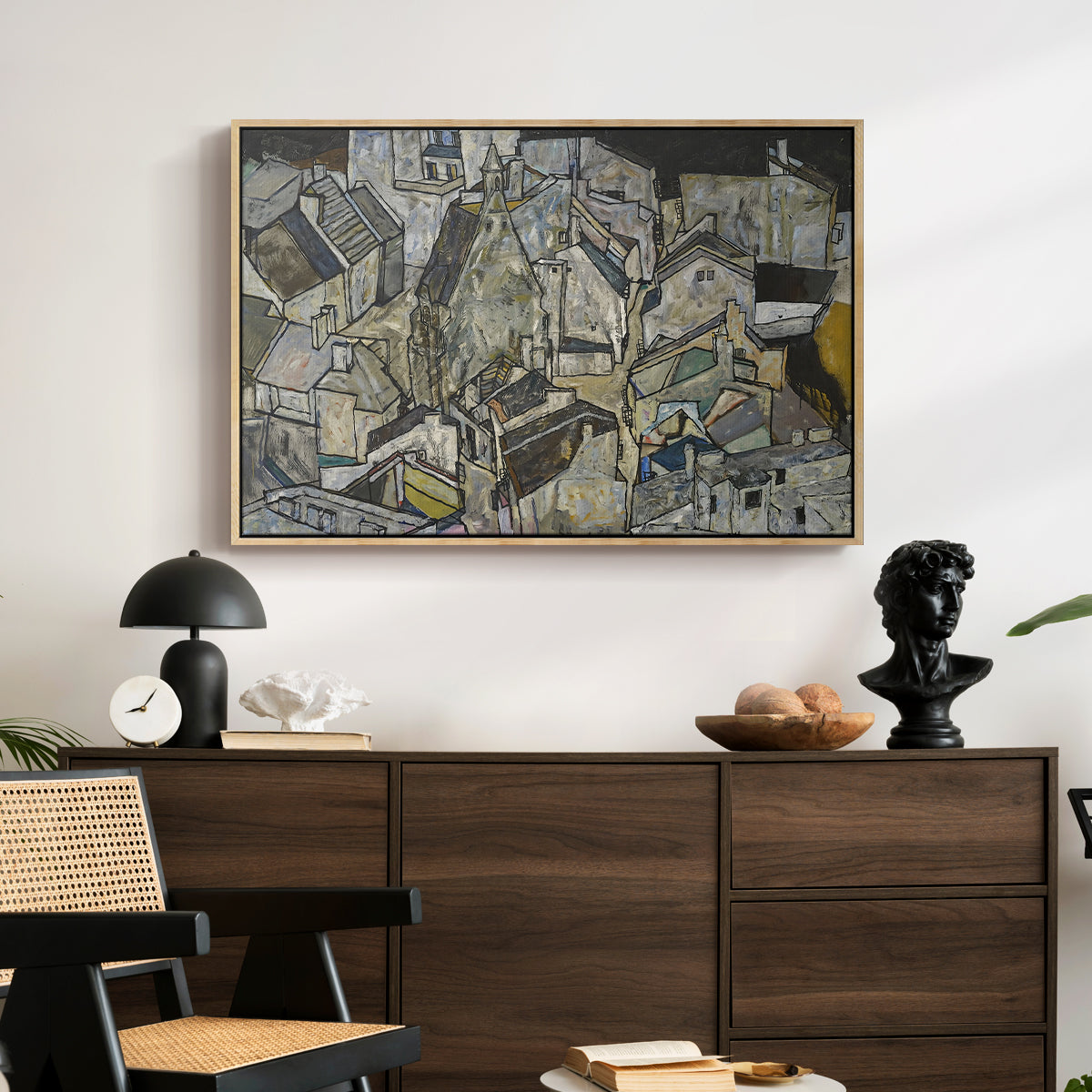 Mödling II, 1918 by Egon Schiele displayed in a natural wood floater framed canvas above a dark wood credenza in an entryway.