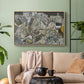 Natural wood floater framed canvas featuring a stylized urban composition with geometric structures and muted tones, displayed above a sofa in a modern living room.