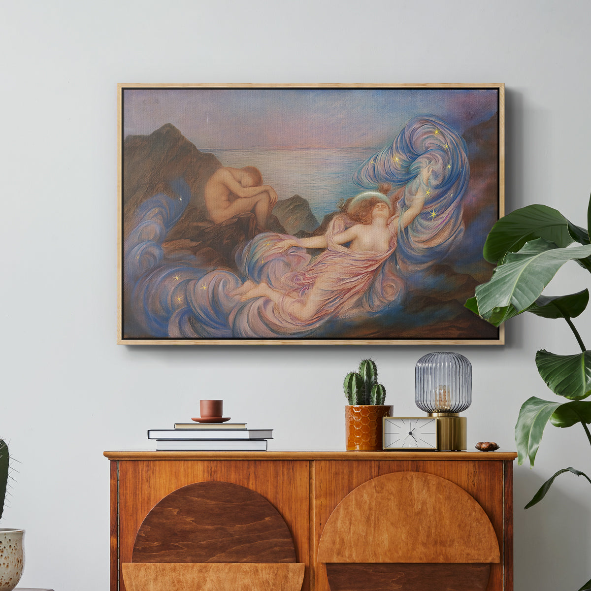 Twilight, 1914 by Evelyn De Morgan in a natural wood floater framed canvas featuring a reclining female figure beneath glowing sky at twilight with soft colors, displayed above a wood console cabinet.
