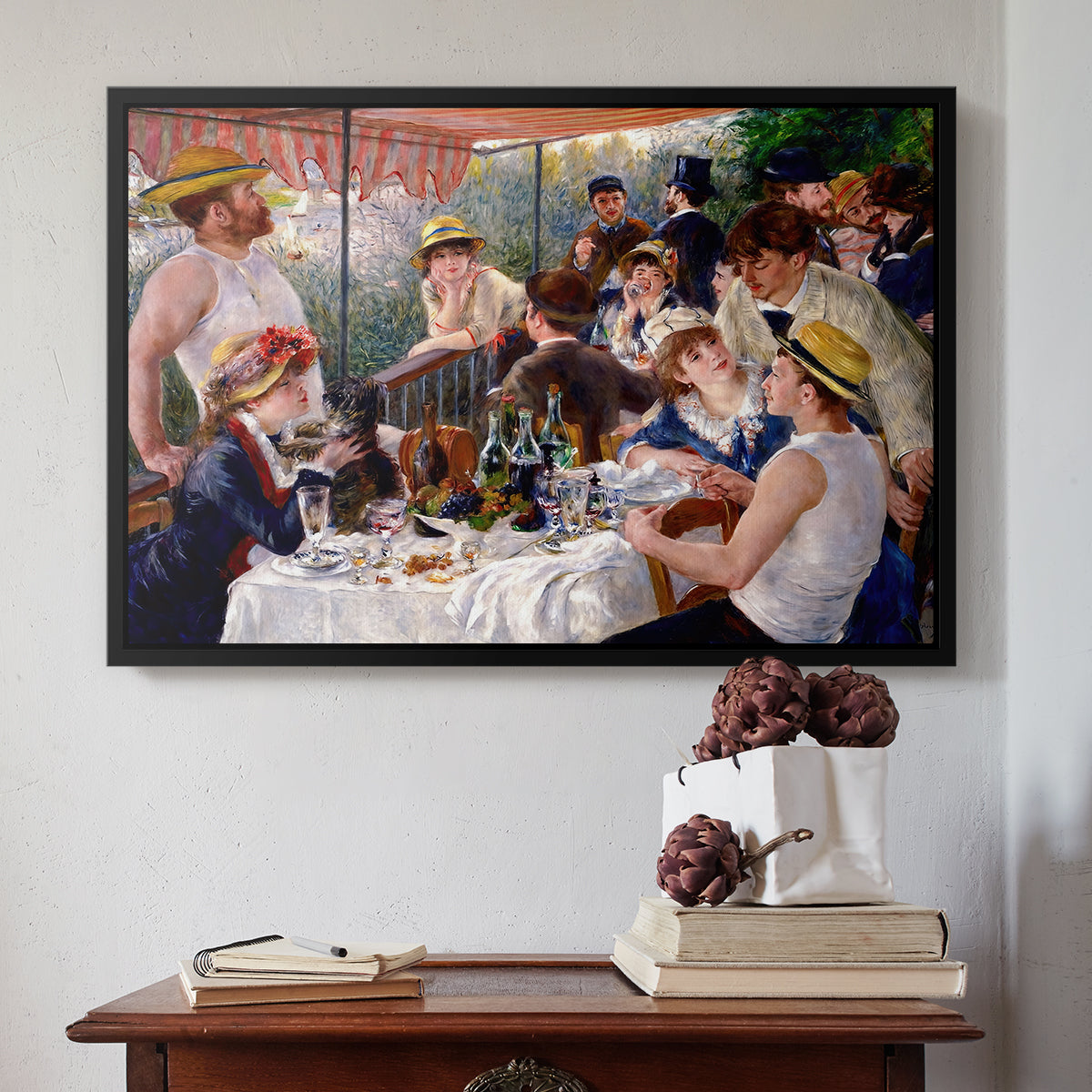 Black floater framed canvas featuring Luncheon of the Boating Party (Le Déjeuner des canotiers), 1880-1881 by Pierre-Auguste Renoir above an entryway table in a minimalist foyer.