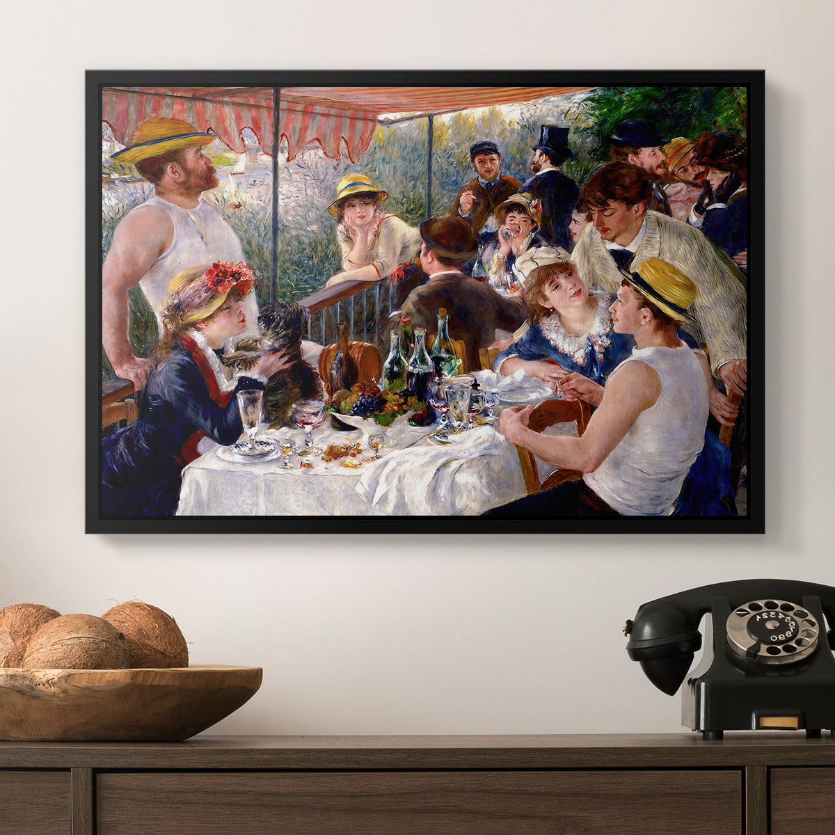 Luncheon of the Boating Party (Le Déjeuner des canotiers), 1880-1881 by Pierre-Auguste Renoir in a black floater framed canvas displayed above a console table in a hallway, featuring a social dining scene with figures seated around table on riverside terrace.