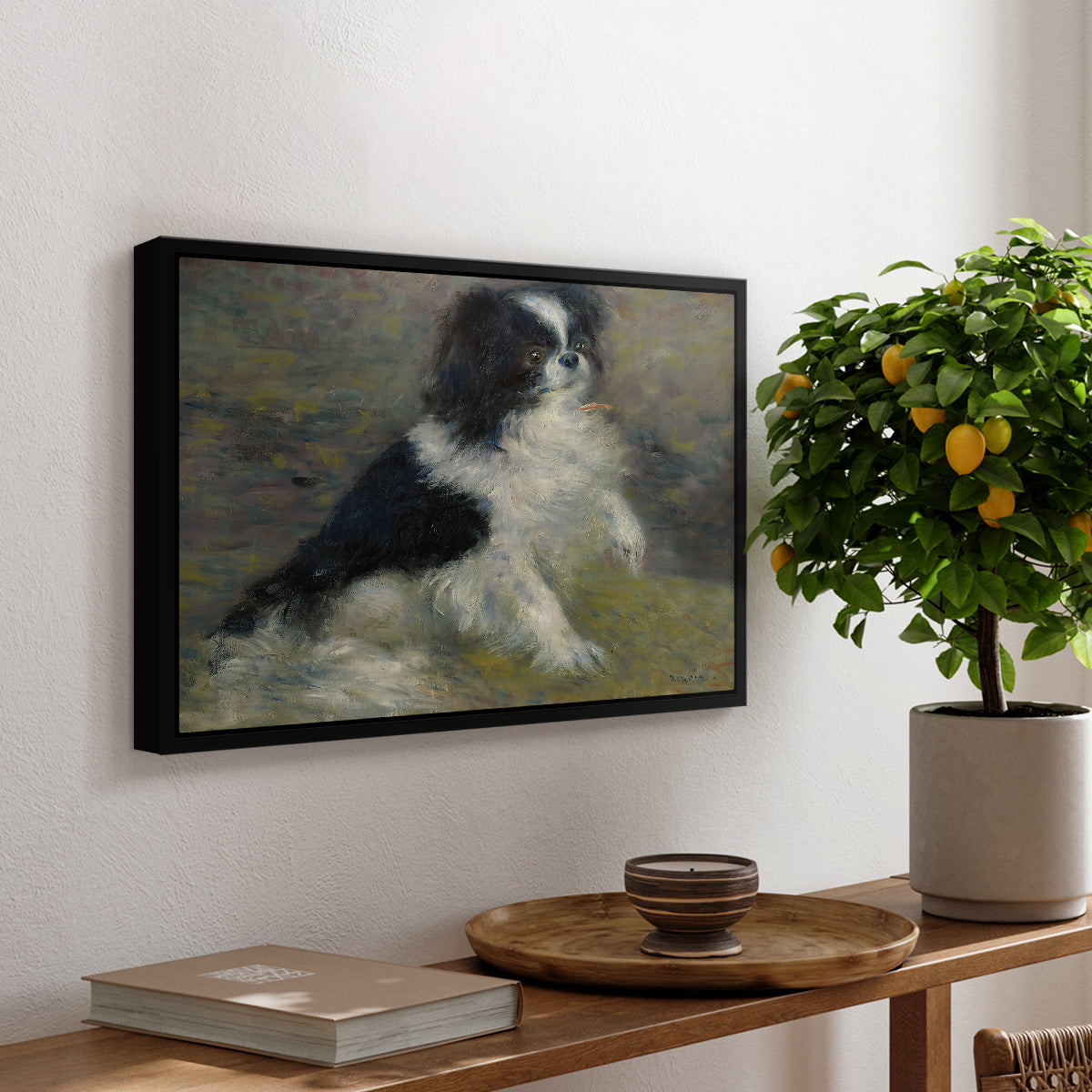 Tama, the Japanese Dog, c. 1876 by Pierre-Auguste Renoir, presented in a black floater framed canvas featuring a small black and white dog standing in shallow water with soft brushstrokes, displayed above a hallway console table.