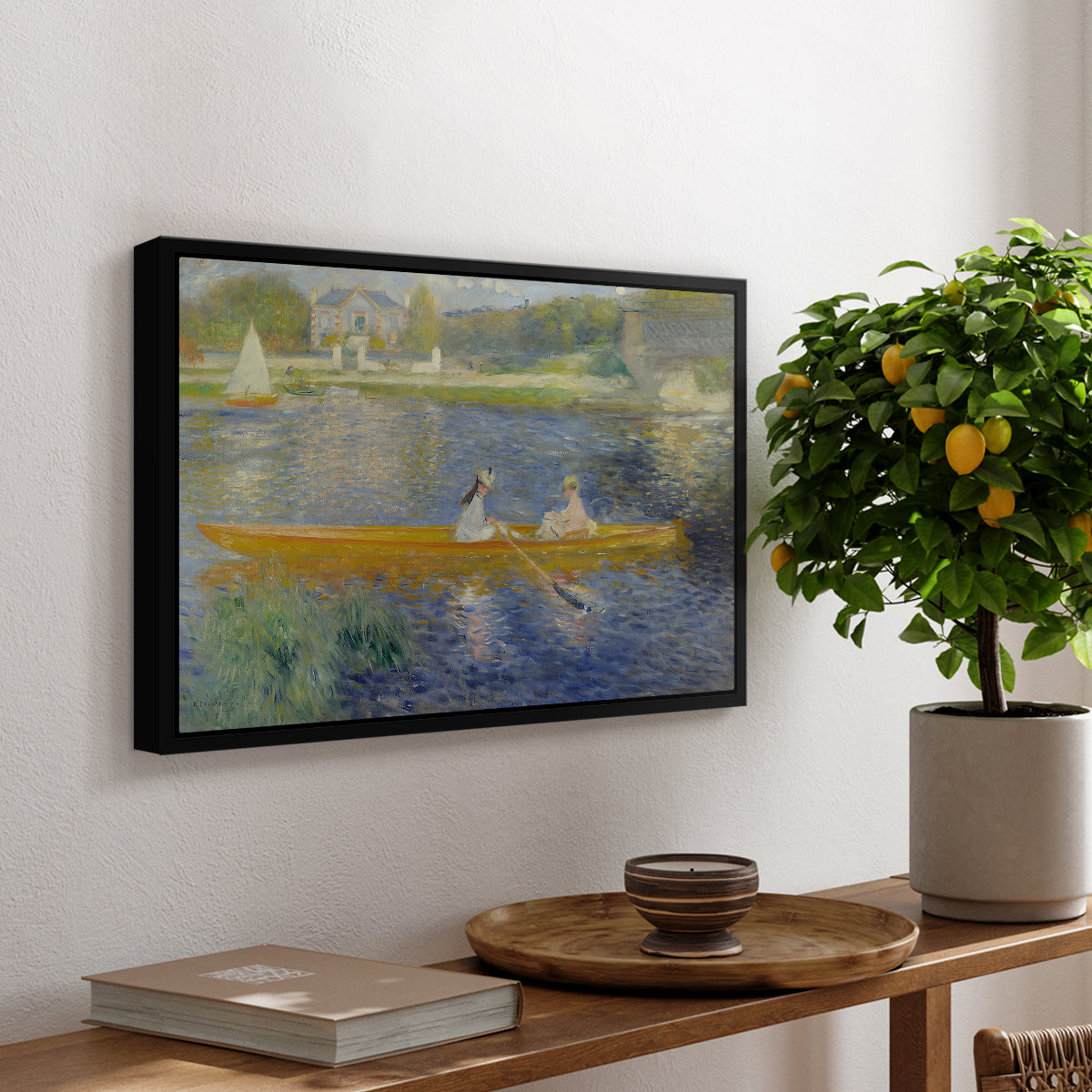 The Skiff (La Yole), 1875 by Pierre-Auguste Renoir, presented in a black floater framed canvas featuring two figures seated in a small boat drifting across calm water, displayed above a hallway console table.