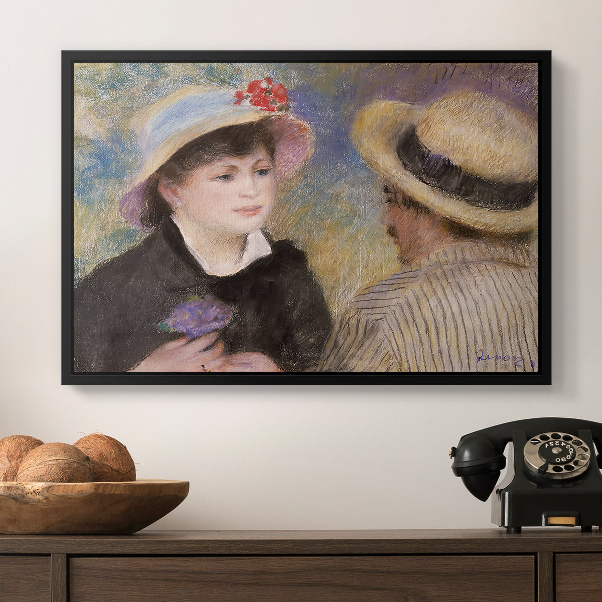 Boating Couple (Aline Charigot and Renoir), c. 1881 by Pierre-Auguste Renoir in a black floater framed canvas displayed above a console table in a hallway, featuring a romantic scene of two figures in casual conversation with soft light.