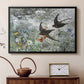 Black floater framed canvas featuring a multiple birds flying together in natural outdoor scene, displayed above a cabinet in a soft-toned living room.
