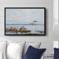 Greylag Geese (Grågäss), 1922 by Bruno Liljefors displayed above a sofa in a living room in a black floater frame, featuring birds standing and resting along shoreline with soft grass and water.