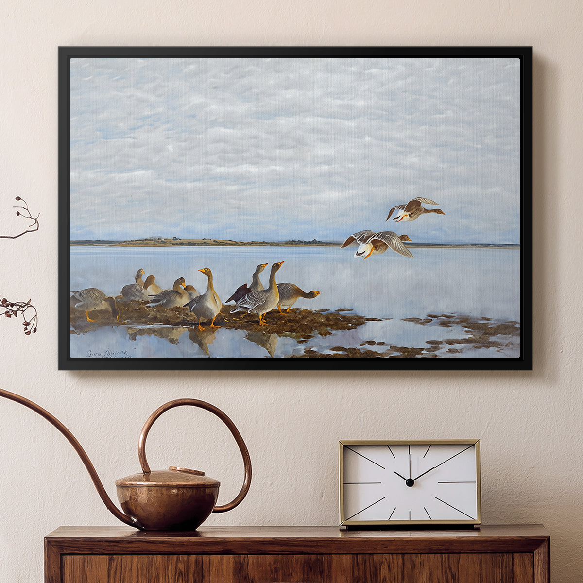 Black floater framed canvas featuring a realistic wildlife scene of geese in calm outdoor environment, displayed above a cabinet in a soft-toned living room.