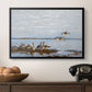 Greylag Geese (Grågäss), 1922 by Bruno Liljefors in a black floater framed canvas displayed above a console table in a hallway, featuring a flock of geese positioned along marshy terrain.