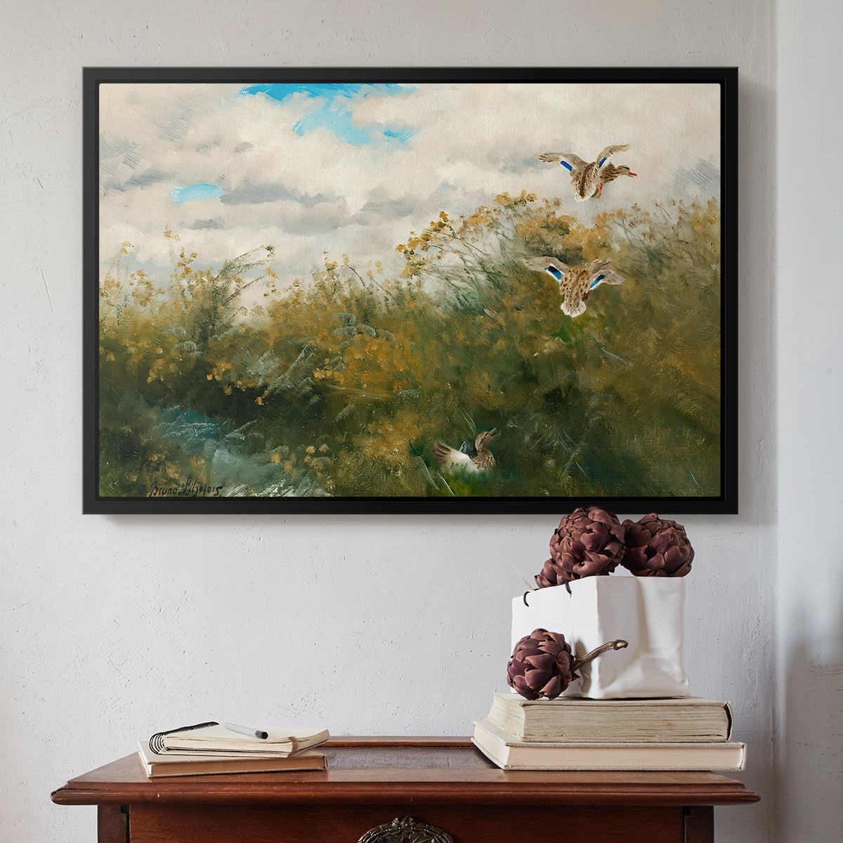 Black floater framed canvas featuring Wild Ducks (Grasänder), 1890 by Bruno Liljefors above an entryway table in a minimalist foyer.