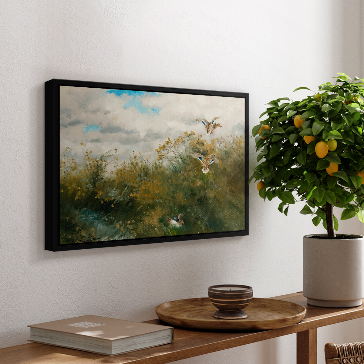Wild Ducks (Grasänder), 1890 by Bruno Liljefors, presented in a black floater framed canvas featuring ducks moving through grassy wetland near water's edge, displayed above a hallway console table.