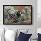 Hooded Crows (Kråkor), 1891 by Bruno Liljefors displayed above a sofa in a living room in a black floater frame, featuring birds standing alert in natural field environment.