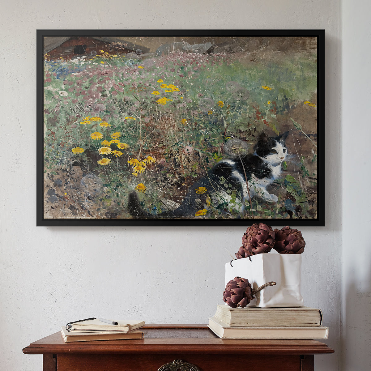 Black floater framed canvas featuring Cat on a Flowery Meadow, 1887 by Bruno Liljefors above an entryway table in a minimalist foyer.
