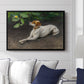 Portrait of a Dog, 1891 by Bruno Liljefors displayed above a sofa in a living room in a black floater frame, featuring a realistic portrait of a resting dog with attentive expression.