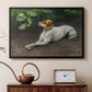 Black floater framed canvas featuring an animal painting of dog stretched out on earthy terrain, displayed above a cabinet in a soft-toned living room.