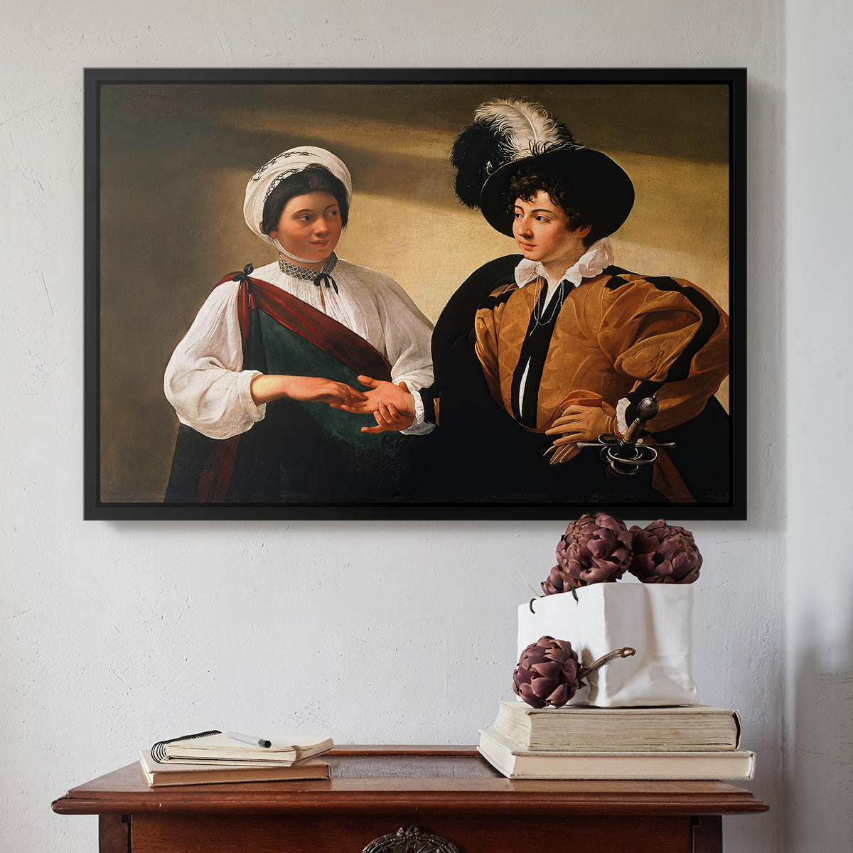 Black floater framed canvas featuring The Fortune Teller (Louvre Version), c. 1595 by Caravaggio above an entryway table in a minimalist foyer.