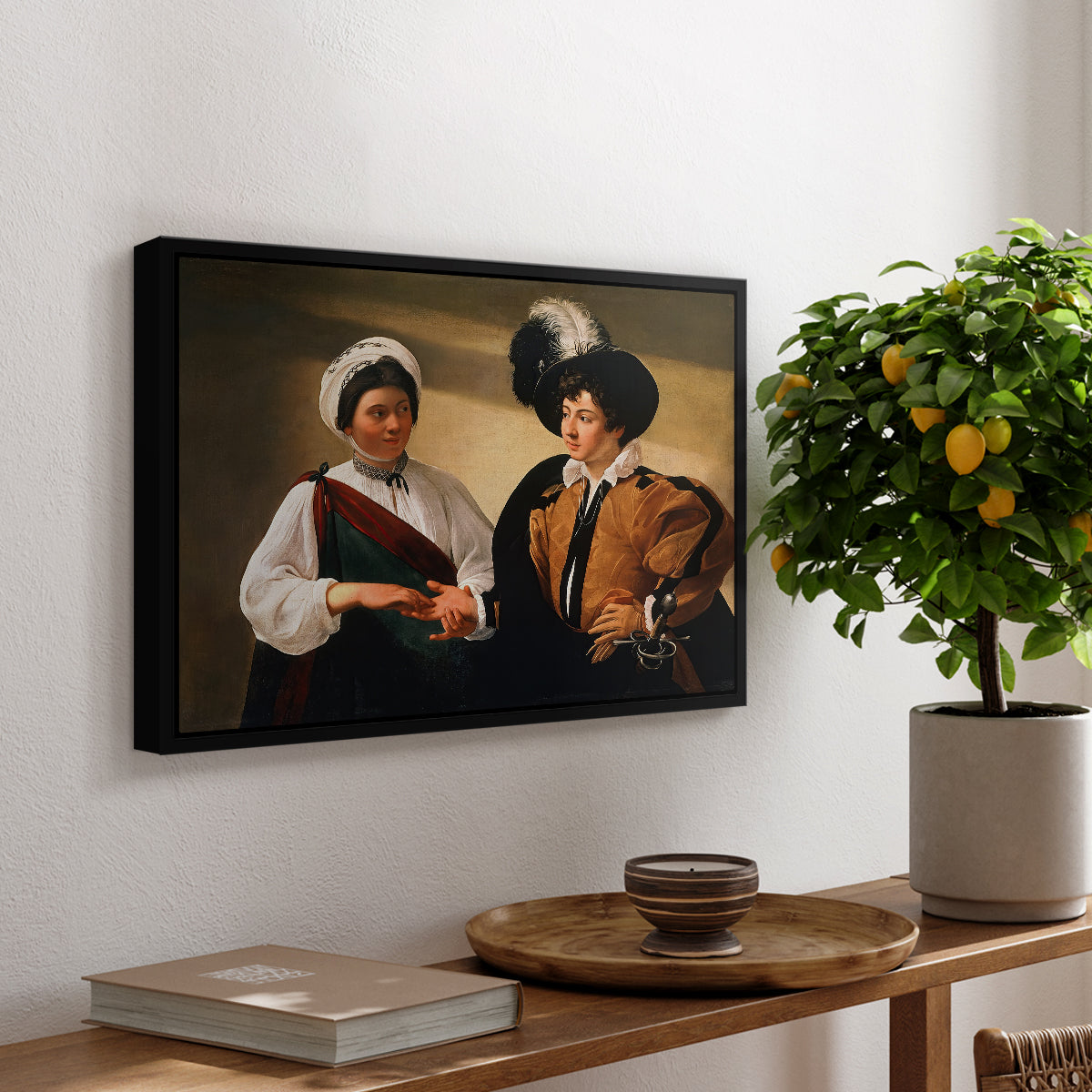 The Fortune Teller (Louvre Version), c. 1595 by Caravaggio, presented in a black floater framed canvas featuring a woman reading a young man's palm while secretly stealing his ring, displayed above a hallway console table.