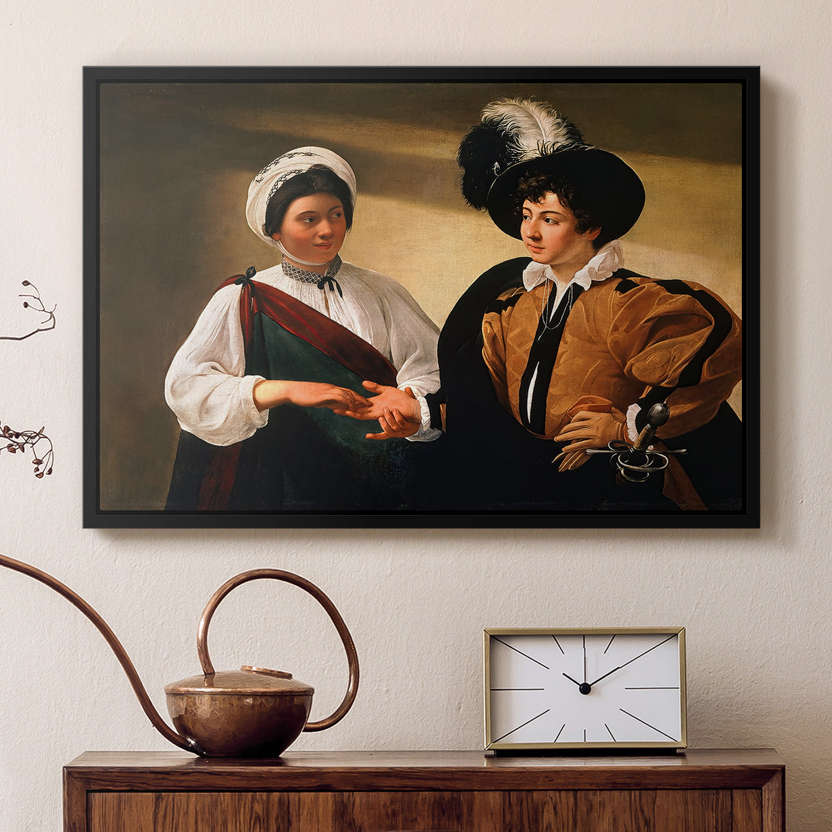 Black floater framed canvas featuring an intimate scene of palm reading with subtle act of theft, displayed above a cabinet in a soft-toned living room.