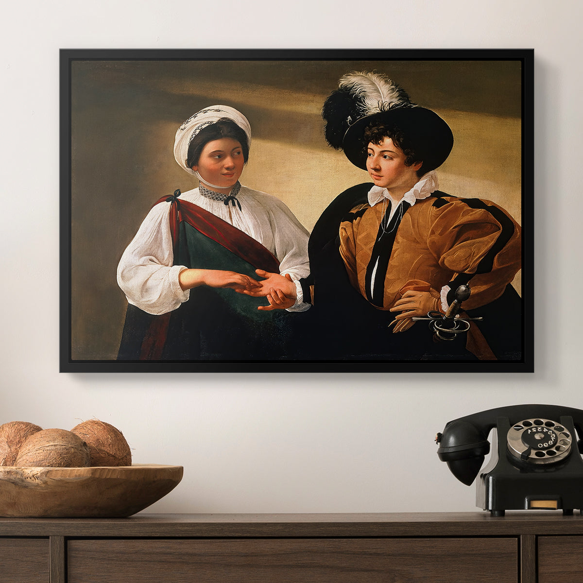 The Fortune Teller (Louvre Version), c. 1595 by Caravaggio in a black floater framed canvas displayed above a console table in a hallway, featuring two figures engaged in fortune telling with hidden deception.