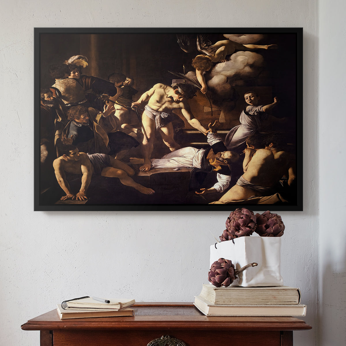 Black floater framed canvas featuring The Martyrdom of Saint Matthew, 1599-1600 by Caravaggio above an entryway table in a minimalist foyer.