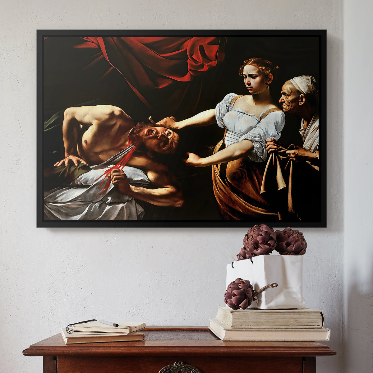 Black floater framed canvas featuring Judith Beheading Holofernes, c. 1599 by Caravaggio above an entryway table in a minimalist foyer.