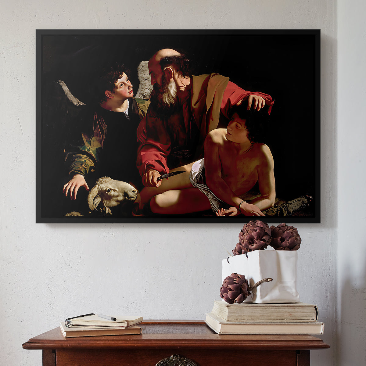 Black floater framed canvas featuring The Sacrifice of Isaac (Uffizi Version), c. 1603 by Caravaggio above an entryway table in a minimalist foyer.