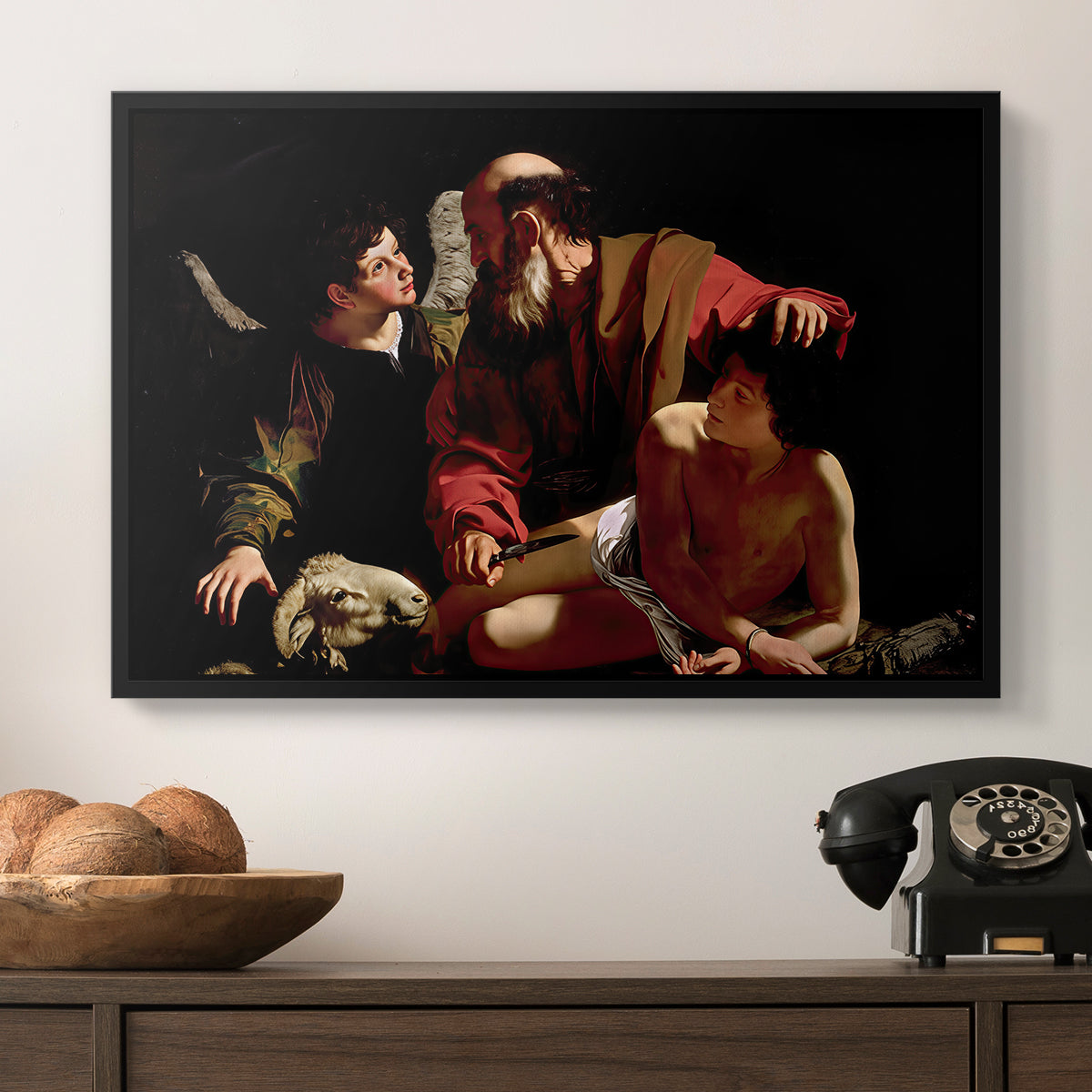 The Sacrifice of Isaac (Uffizi Version), c. 1603 by Caravaggio in a black floater framed canvas displayed above a console table in a hallway, featuring an intense religious narrative with figures in close physical struggle.